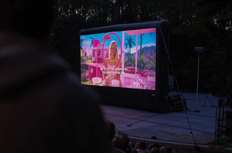 Openluchttheater omringd door bos waar bezoekers op zomeravonden films kijken onder de sterren